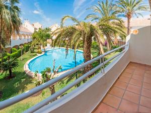 a balcony with a swimming pool and palm trees at Apartamento Esmeralda VyB in Denia