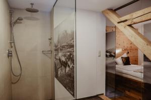 baño con cabina de ducha de cristal y cama en Landhaus Alpengruss, en Kössen