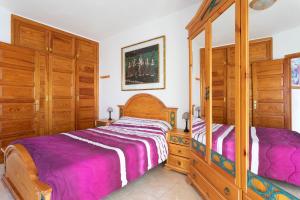 a bedroom with two beds and wooden cabinets at Apartment direkt am Meer in Costa Del Silencio +22 photos
