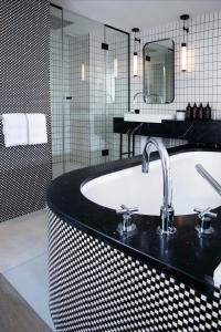 a bathroom with a sink and a bath tub at Maison ELLE Paris in Paris