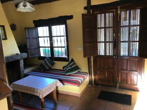 a living room with a bench in front of two windows at Casa Rural Albahaca in Jimera de Líbar +26 photos