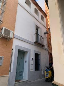 skuter zaparkowany przed budynkiem z zielonymi drzwiami w obiekcie Turistic Apartment Sevillanos SL w Sewilli