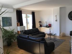 un soggiorno con divano in pelle nera e tavolo di Appartement terrasse vue mer / nice a Nizza
