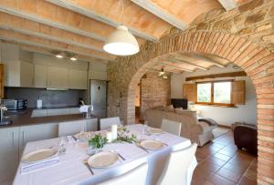 una sala da pranzo con tavolo bianco e una cucina di Can Jan de Castanyet a Santa Coloma de Farners