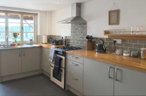 a kitchen with white cabinets and a stove top oven at The Mill at Rose Villa Farm in Hereford