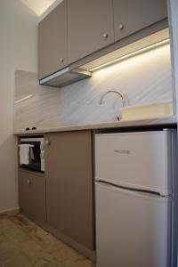 a kitchen with a white refrigerator and a sink at Studio Candia in Kandia