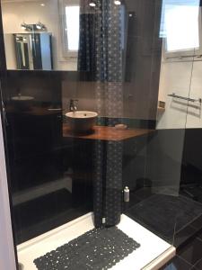 a black bathroom with a sink and a shower at Appartement terrasse vue mer / nice in Nice