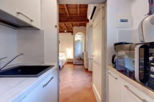 フィレンツェにあるMamo Florence - Cupolone Apartmentの白いキャビネットとシンク付きのキッチン