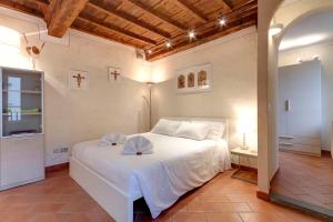 フィレンツェにあるMamo Florence - Cupolone Apartmentのベッドルーム1室(大きな白いベッド1台、帽子2つ付)