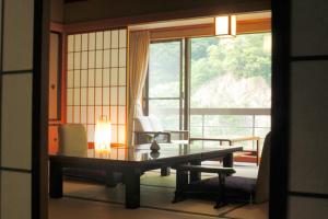 een kamer met een tafel voor een raam bij Enraku in Kurobe