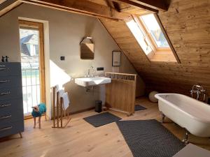 a bathroom with a tub and a sink in a attic at Himmelschlüssel Apartments in Mitterbach