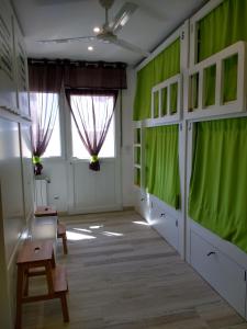 um quarto com paredes e janelas verdes e uma porta em Albergue La Magia del Camino em Comillas