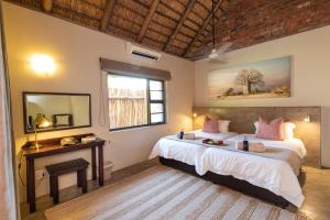 a bedroom with a large bed and a mirror at Senalala Safari Lodge in Klaserie Private Nature Reserve