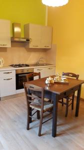 a kitchen with a wooden table with chairs and a stove at Casa Mirella in Bolsena +56 photos