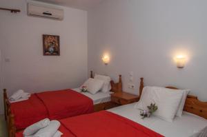 a room with two beds with red and white sheets at Musses in Kókkinon Nerón