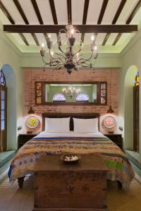 a bedroom with a large bed and a chandelier at Calcutta Bungalow in Kolkata