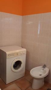 a bathroom with a toilet and a washing machine at Casa Mirella in Bolsena