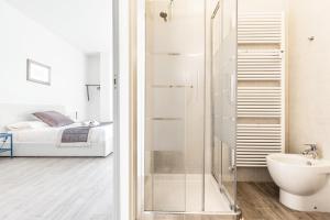 a bathroom with a shower and a bedroom with a bed at Central City Rooms Executive Suite in Bologna
