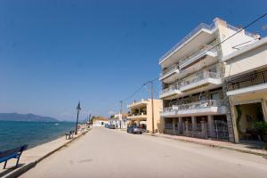 an empty street in front of a building next to the water at Diavlos Oreon in Oreoi