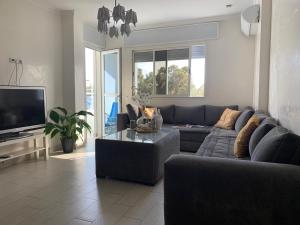 a living room with a couch and a tv at Appart Hotel Monaco in Tangier