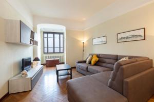 - un salon avec un canapé et une télévision dans l'établissement Palazzo BellaVista by Impero House, à Stresa