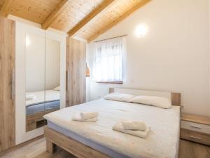 a bedroom with a bed with two towels on it at Attractive Holiday Home with Pool bubble bath Patio Courtyard in Barbariga