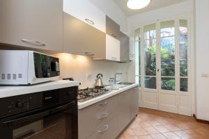 une cuisine avec un micro-ondes et une cuisinière four supérieur dans l'établissement Palazzo BellaVista by Impero House, à Stresa