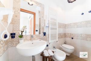 uma casa de banho branca com um lavatório e um WC em B&B Palazzo Pinto 2 em Vietri