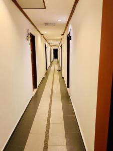 a long corridor with white walls and a long hallway at D lima beach inn in Pantai Cenang