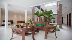 Elle comprend un salon doté d'un mobilier en bois et d'oreillers verts. dans l'établissement RedDoorz Syariah near Universitas Negeri Malang, à Malang
