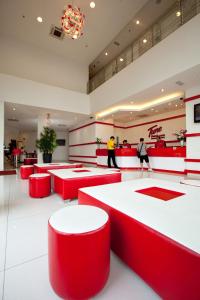 a restaurant with red tables and people walking in the background at Tune Hotel - Danga Bay Johor in Johor Bahru