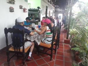 un grupo de personas sentadas en una mesa en un restaurante en Hostal Villa Cecilia en Villavieja