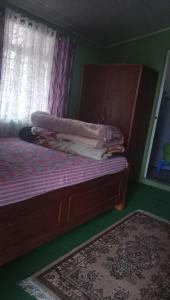 a bedroom with a bed with a window and a rug at Vamoose Sanjeema Tea Estate Homestay in Kurseong
