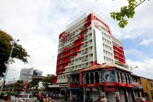 a tall red and white building on a city street at Tune Hotel Georgetown Penang in George Town