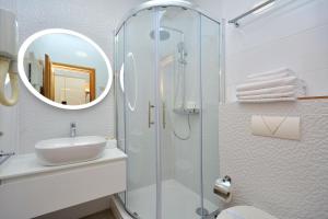 a bathroom with a shower and a sink and a mirror at Hotel Adriana in Split