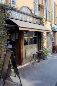 a cafe with tables and chairs outside of a building at Sforza Apartment Near Duomo in Milan