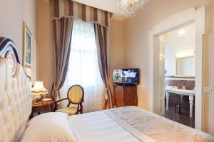 a hotel room with a bed and a television at Grand Hotel Rimini in Rimini