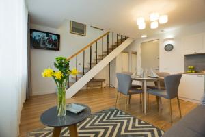 a living room with a table with a vase of flowers at Relax Birstonas in Birštonas