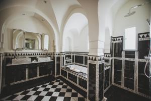 La salle de bains est pourvue d'un sol en damier noir et blanc. dans l'établissement Les Deux Tours, à Marrakech