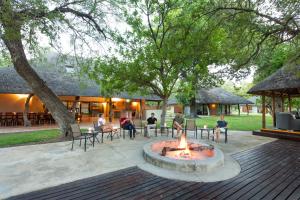 a group of people sitting around a fire pit at Senalala Safari Lodge in Klaserie Private Nature Reserve