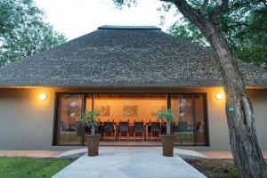 a house with glass doors and a patio with chairs at Senalala Safari Lodge in Klaserie Private Nature Reserve +62 photos