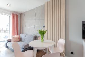 a living room with a couch and a table and chairs at Apartment Pink Flamingo by Renters in Międzyzdroje