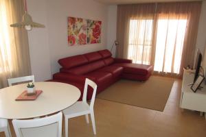 een woonkamer met een rode bank en een tafel bij La Isla in Murcia