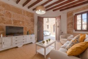 a living room with a tv and a couch and a table at YupiHome Holiday Home Ca Na Serrieta in Alcudia