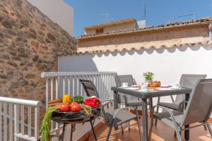 a table with fruits and vegetables on a balcony at YupiHome Holiday Home Ca Na Serrieta in Alcudia