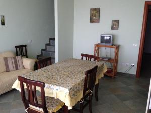 un soggiorno con tavolo e TV di casa con vista a Chia a Chia