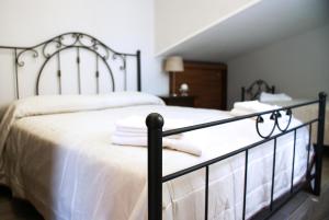 un letto con lenzuola bianche e asciugamani di SAN - Luxury Apartment a Santa Maria di Castellabate
