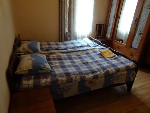 a bed in a room with a blue plaid blanket at Medico and Suliko Guest House in Kutaisi