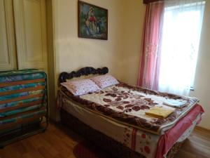 a bedroom with a bed and a window at Medico and Suliko Guest House in Kutaisi