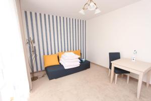 a room with a couch and a desk and a table at Ośrodek Wczasowy GAMA in Rewal